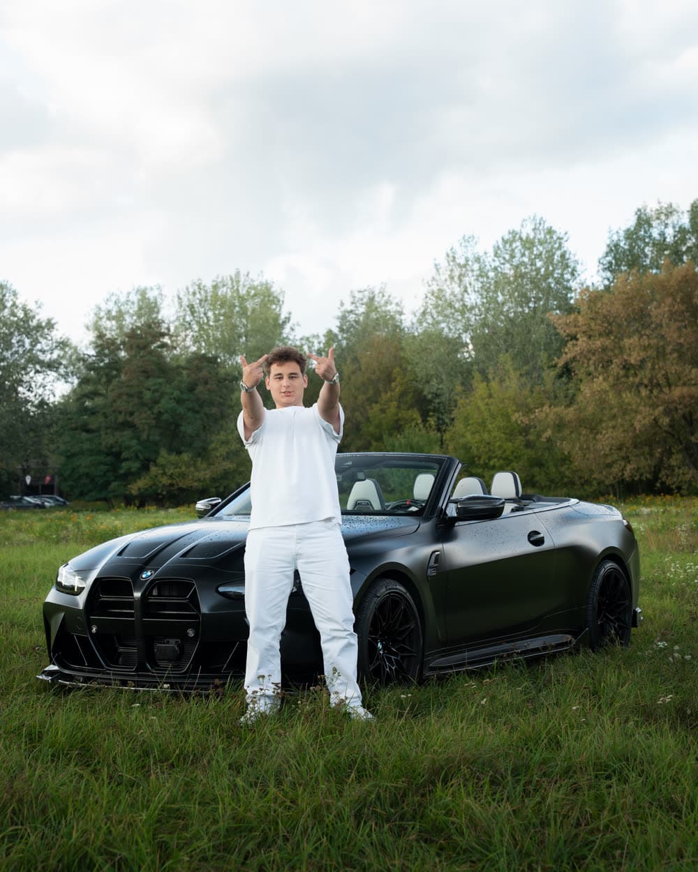 Gerox w białym stroju przy czarnym kabriolecie BMW M4